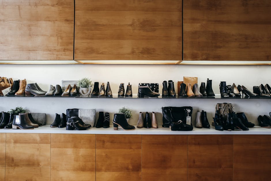 A stylish display of various shoes on wooden shelves in a modern boutique setting.