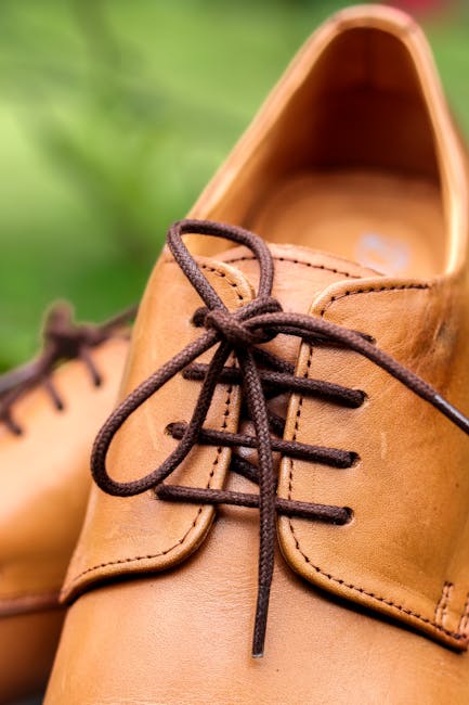 Close-up of tan leather shoes with brown shoelaces outdoors.